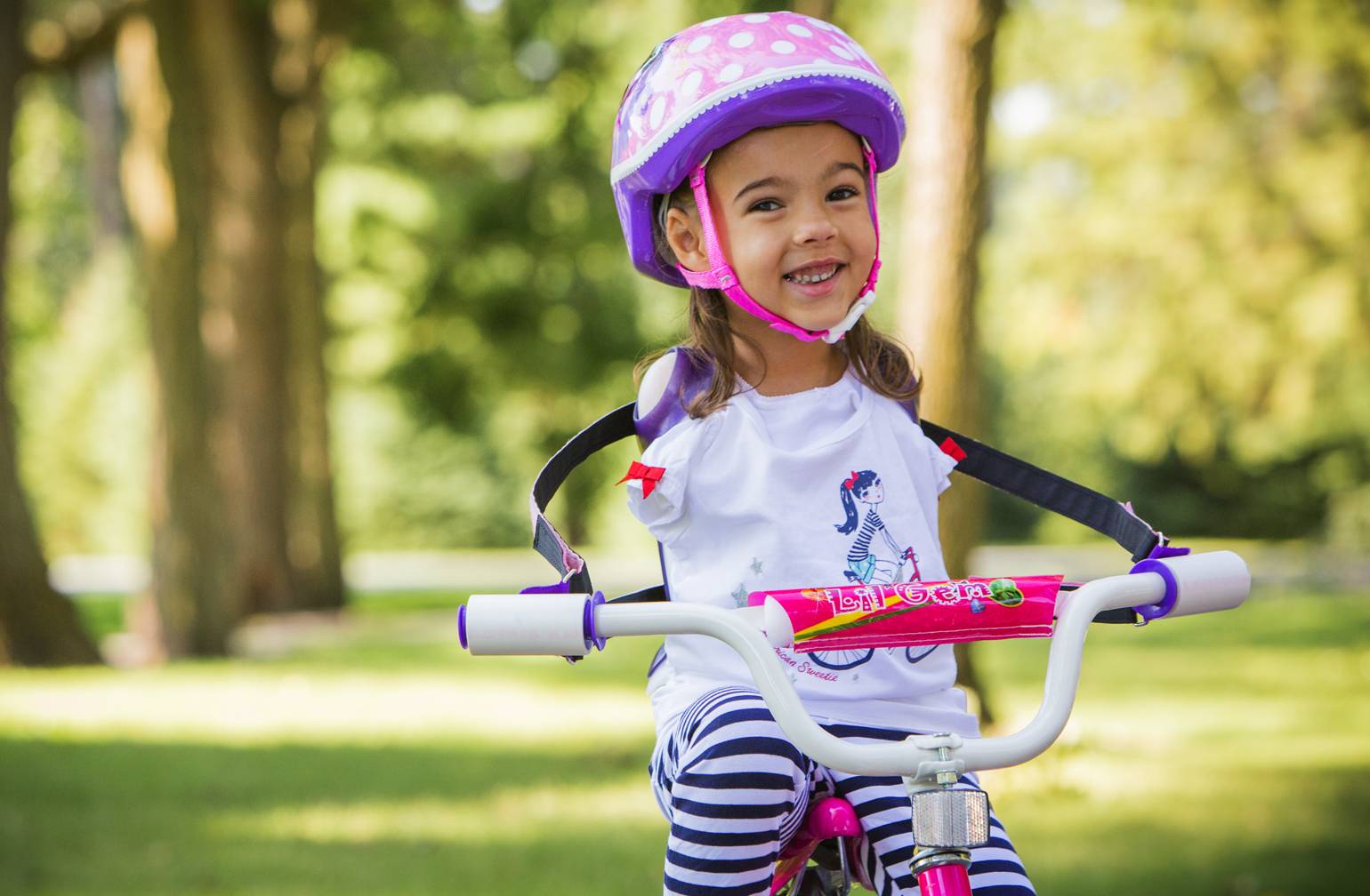 Ruth Evelyn, Gillette Children's patient who was born without arms poses with her bike