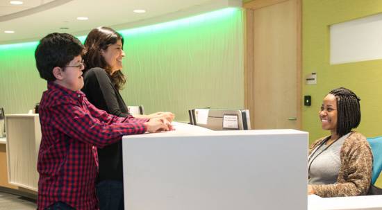 Gillette patient Michael Ruud and his mom checking in a front desk