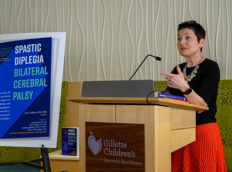 Lily Collison, author of the Gillette Press book about Spastic Diplegia, speaks at a podium at the launch event