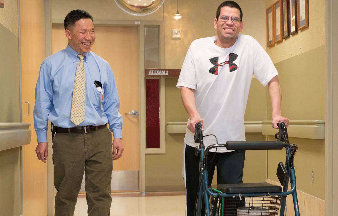 Lee Schuh, MD, walks down hallway with patient at Gillette children's specialty healthcare