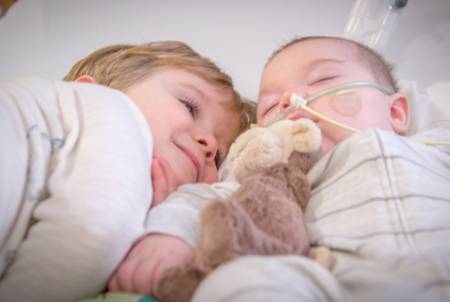 Felix and his brother Oscar cuddle in Gillette Children's PICU